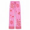 Pink pajama pants with red celestial designs on a white background