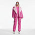 Person wearing a pink outfit with a fur-lined coat on a white background