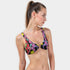 Woman wearing a colorful patterned bikini top on a white background