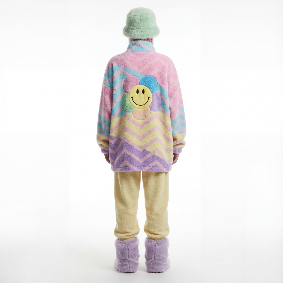 Person wearing a colorful sweater with a smiley face design on a white background