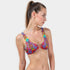 Woman wearing a colorful bikini top against a plain background