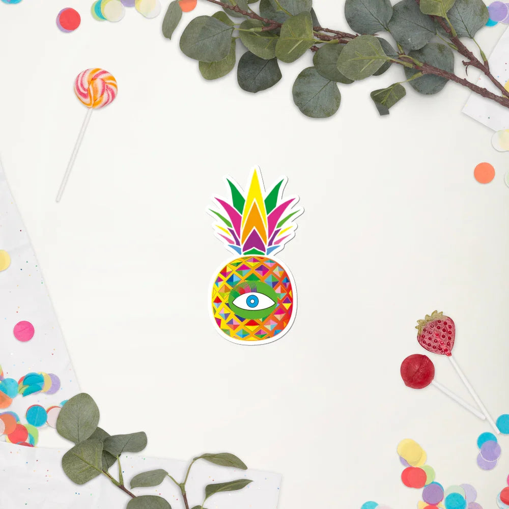 Colorful geometric pineapple sticker with an eye design, surrounded by leafy branches, lollipops, and multicolored confetti